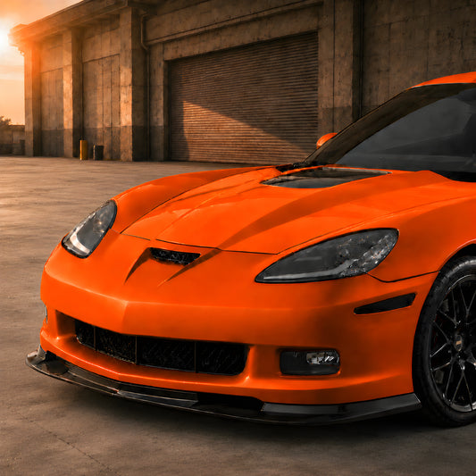 Orange Corvette front bumper cover with grille, fog light openings, and splitter lip