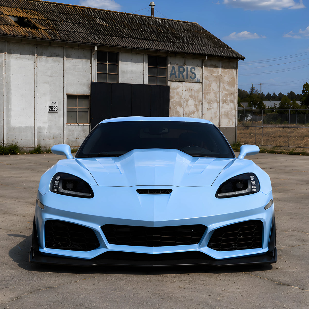 Light blue front bumper cover with black grille, mesh intakes, and splitter