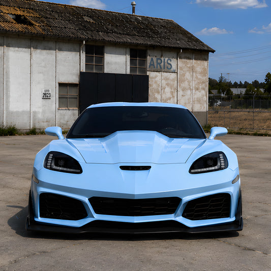 Light blue front bumper cover with black grille, mesh intakes, and splitter