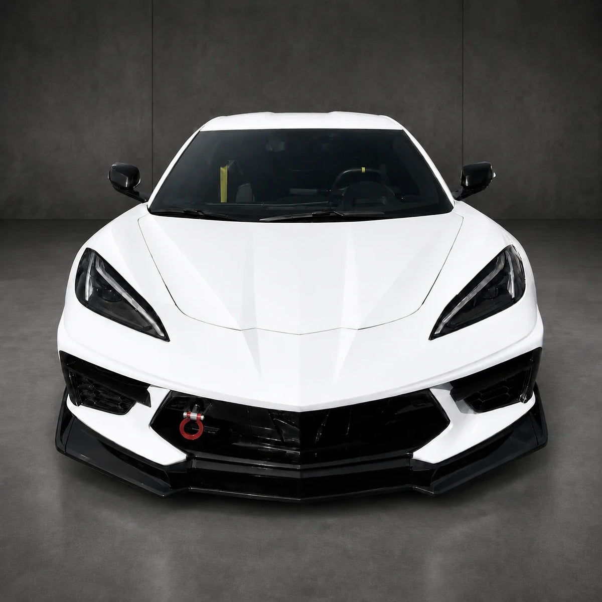 Front splitter kit on white sports car, black aero lip along lower bumper