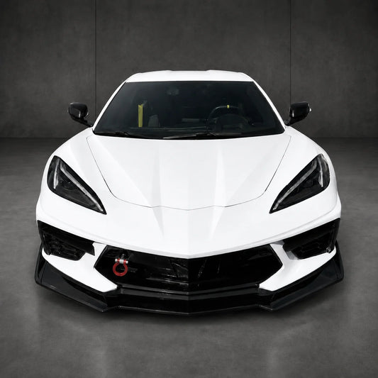 Front splitter kit on white sports car, black aero lip along lower bumper