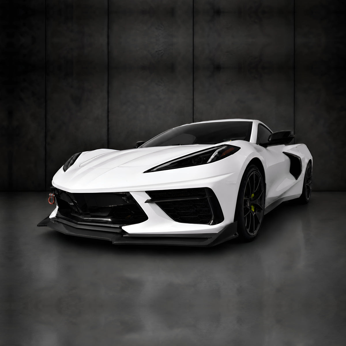 White sports car with extended black front splitter and aerodynamic canards