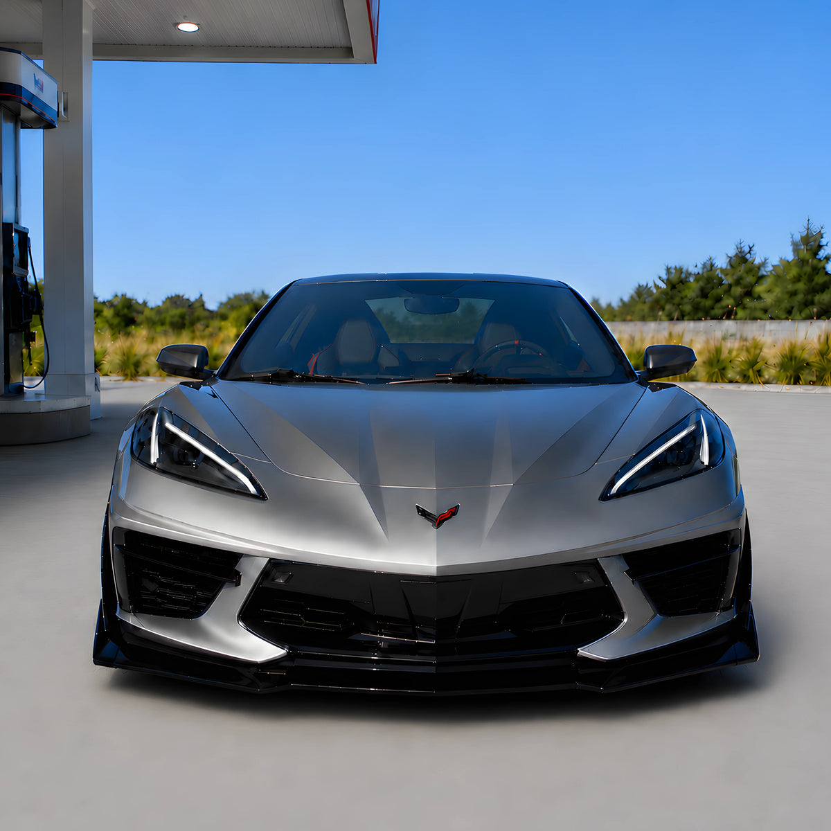Black front splitter lip on silver sports car front bumper