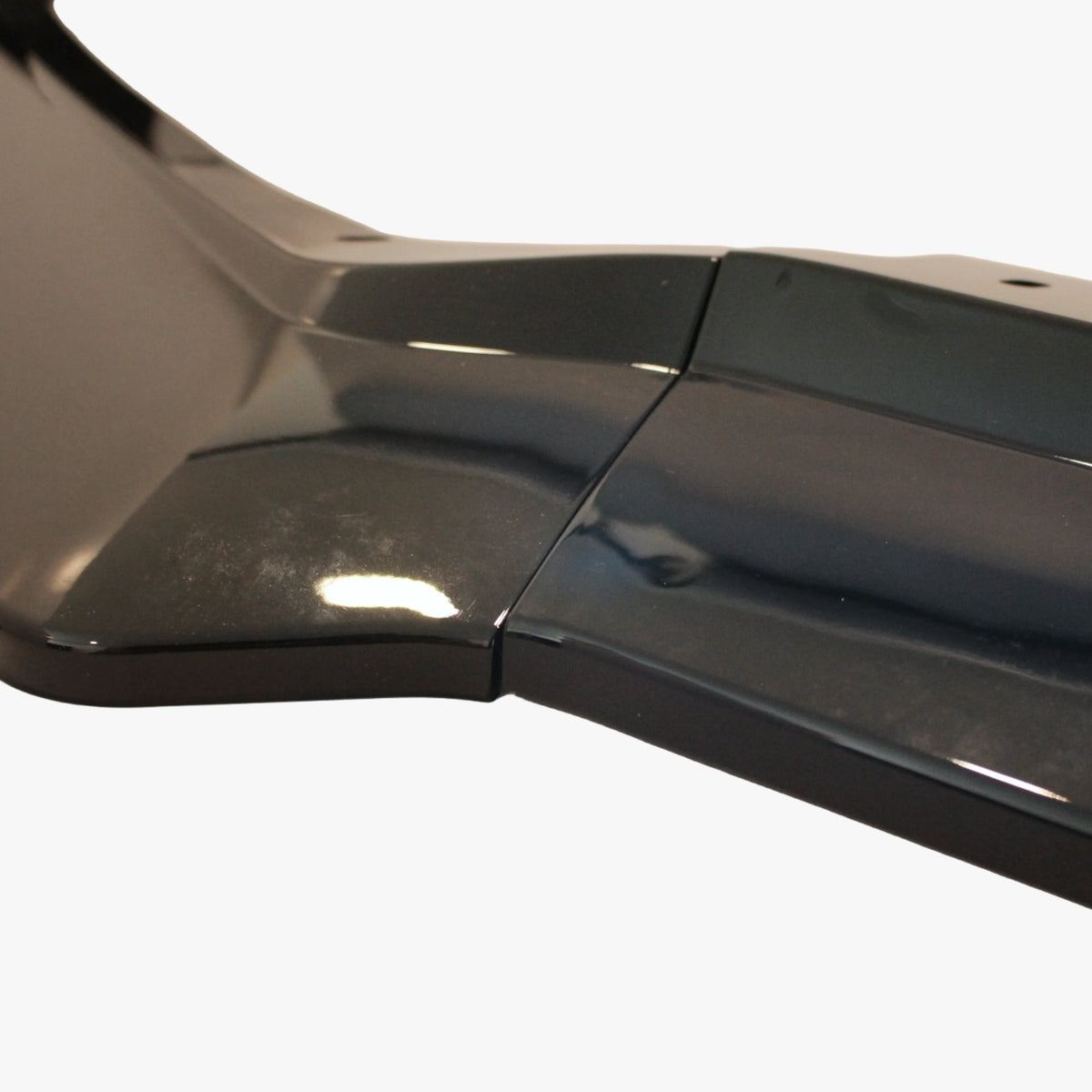 Glossy black front splitter section with side seam and curved edge