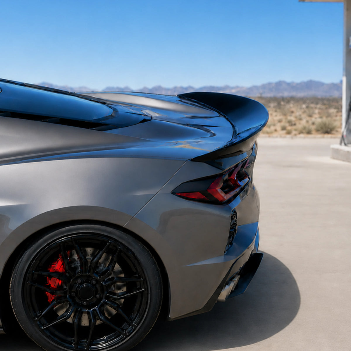Rear ducktail spoiler close-up, glossy black fin on sports car rear quarter