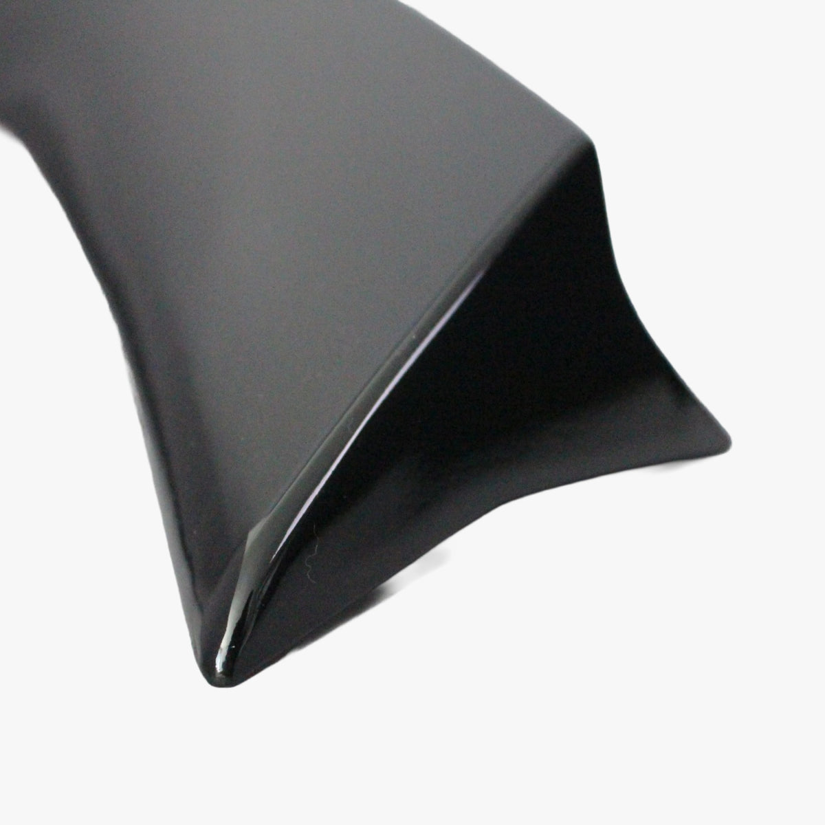 Close-up of black low profile rear spoiler tip and glossy edge